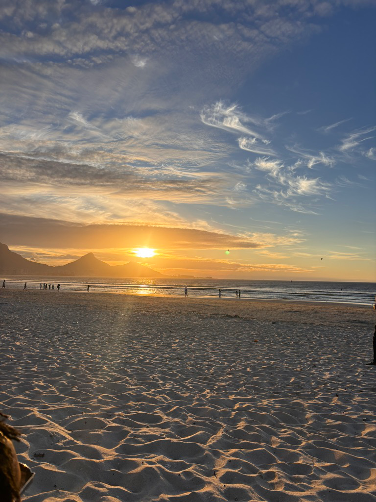 Cape Town beach at sunset with mountains in the distance